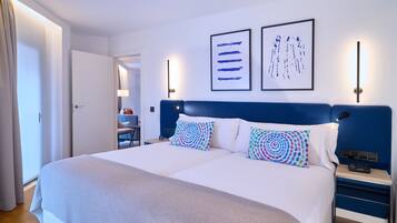 A double bed with a blue headboard, two side tables, and a bedside lamp.