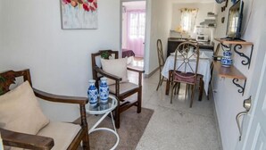 A compact living space with a dining area, a kitchen, and a hallway leading to an outdoor area. - Apartamentos Magallanes Romana (La Romana)