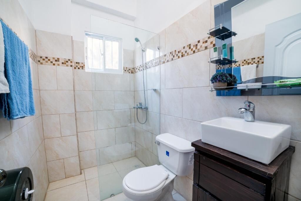 Une salle de bain avec des toilettes, un lavabo et une douche.