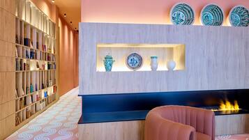 Un interior moderno con una estantería, platos decorativos y una chimenea.