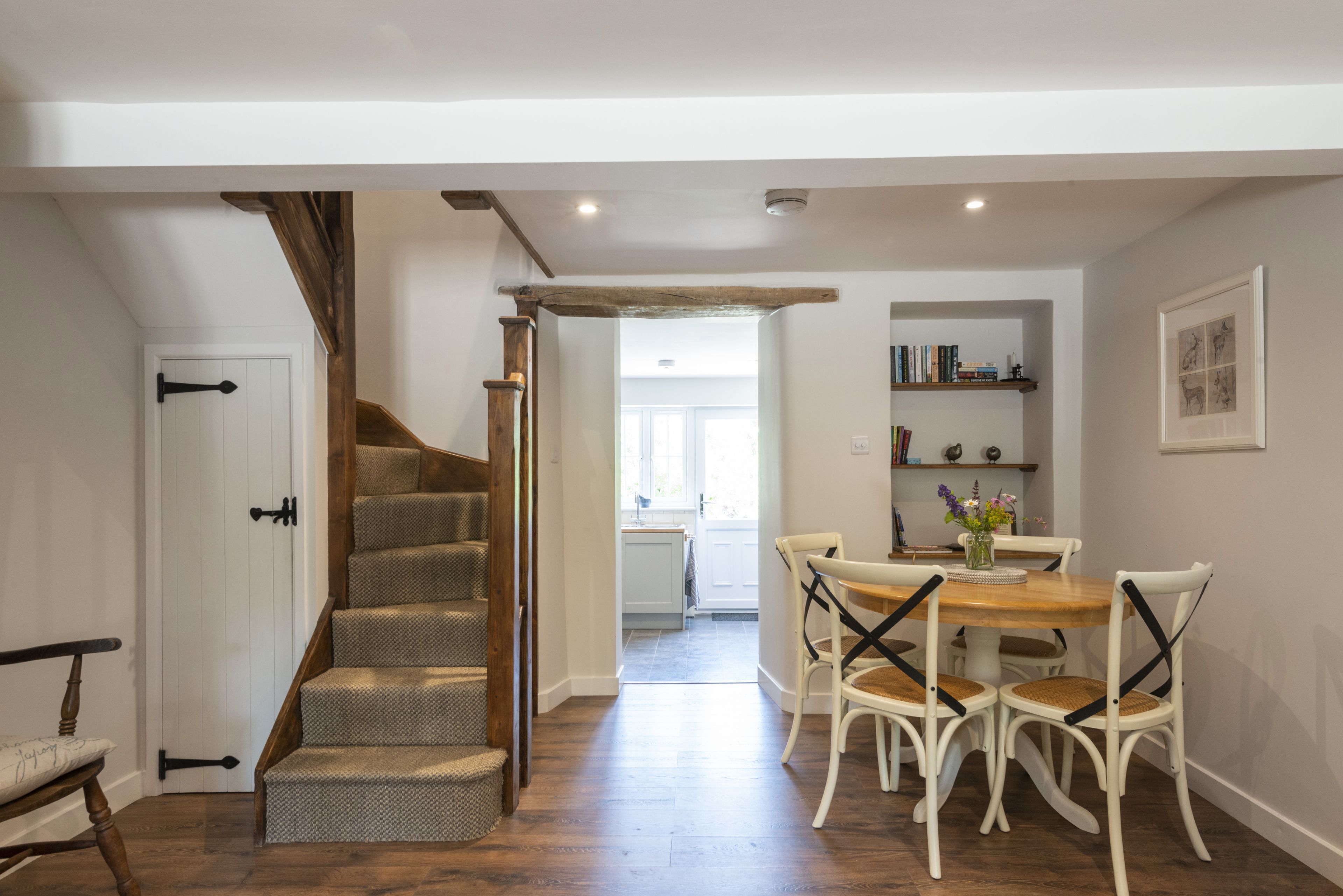 A staircase leading to a dining area with a table and chairs.