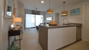 A modern kitchen with a central island, pendant lighting, and a large mirror. - Los Flamencos 4004 - Two Bedroom Apartment, Sleeps 5 (Punta del moral)