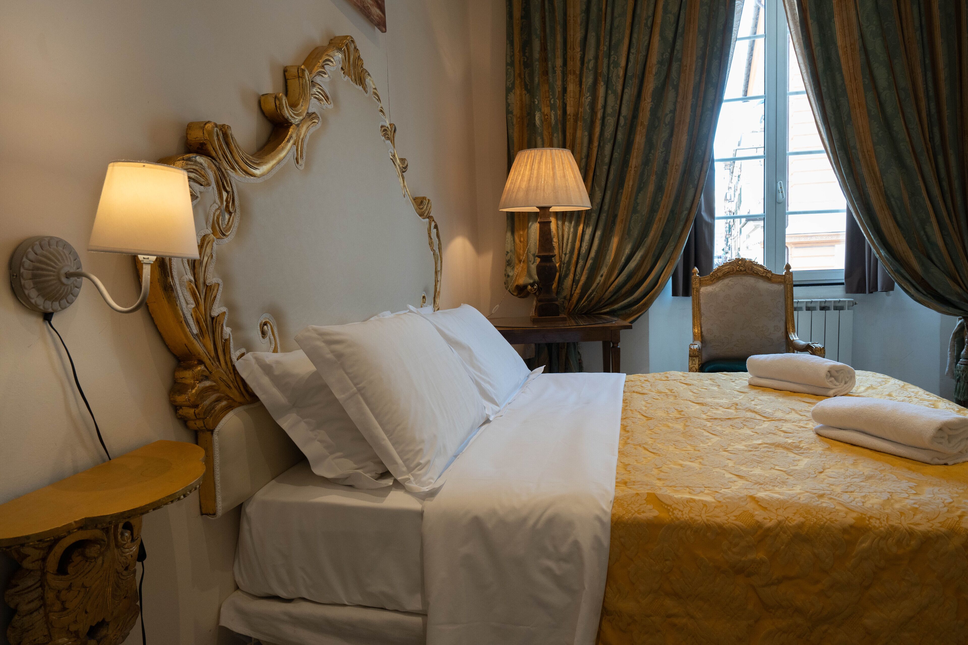 Une chambre d’hôtel avec un lit, une table de chevet, une lampe et une chaise.