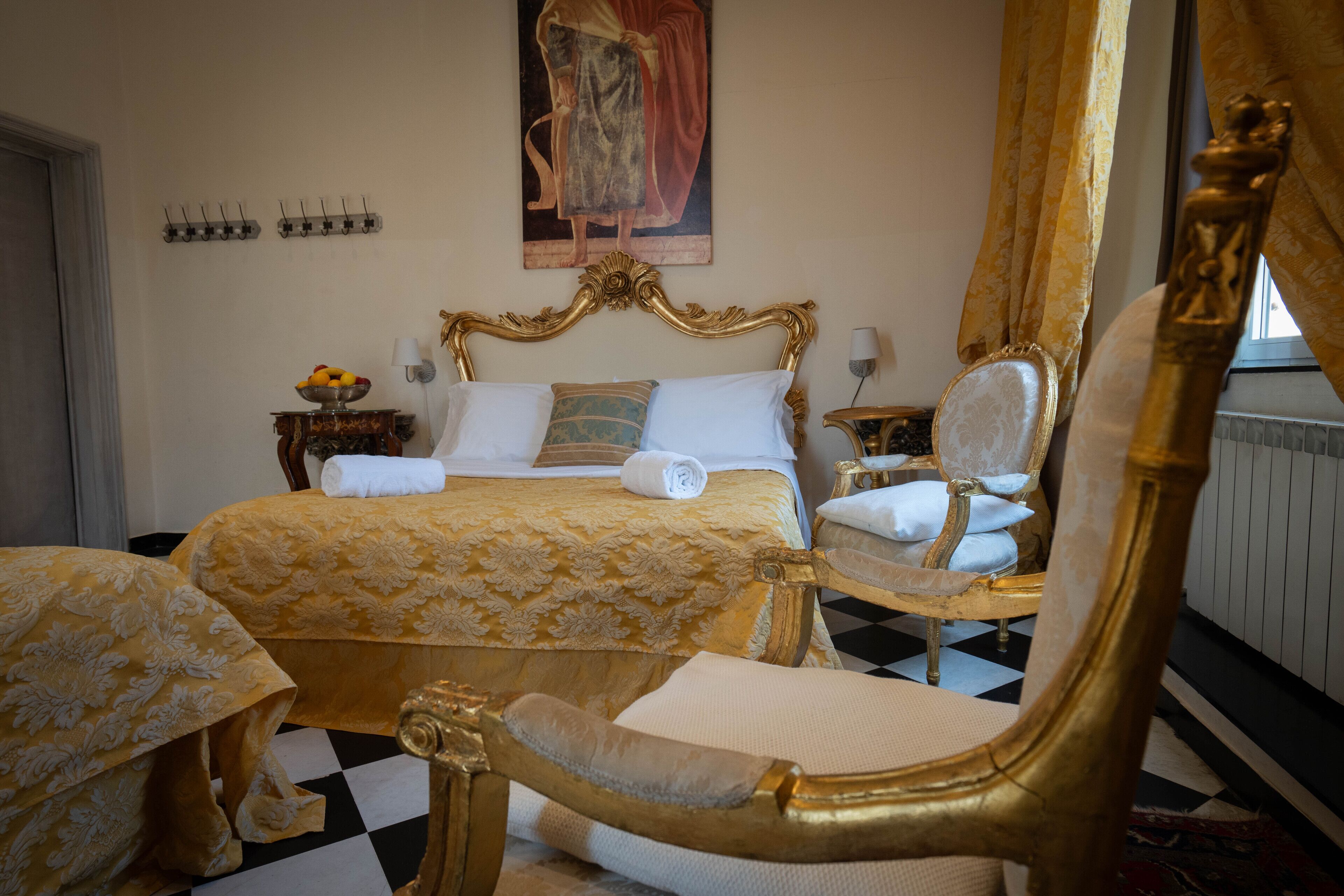 Een luxueuze slaapkamer met een groot bed, versierd goudkleurig meubilair en een geruite vloer.