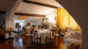 A dining area with a table set for four, surrounded by wooden chairs. - San Giorgio Rooms (Genoa)