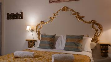 Ein Bett mit goldenem Kopfteil, Kissen mit blau-weißem Muster und einer gelben Blumenbettdecke.
