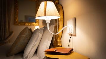 Eine Lampe auf einem Nachttisch mit Kissen und Geldbörse.