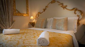 Una habitación de hotel con una cama grande, un cabecero ornamentado y un espejo en la pared.
