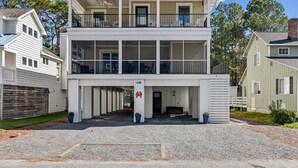 A two-story house with a balcony on the upper floor, a garage entrance, and a number 646 sign. - 7BR Pet-Friendly Home w/ EV Charger & Room for 18+ Guests (Bethany Beach)