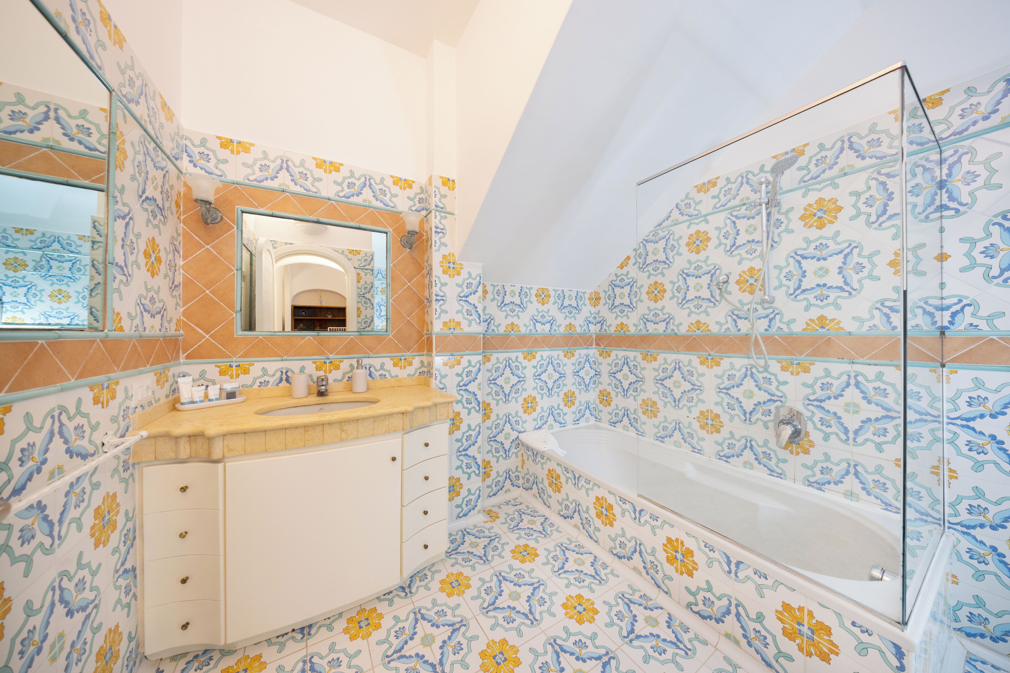 Un baño con bañera, lavamanos y espejo.