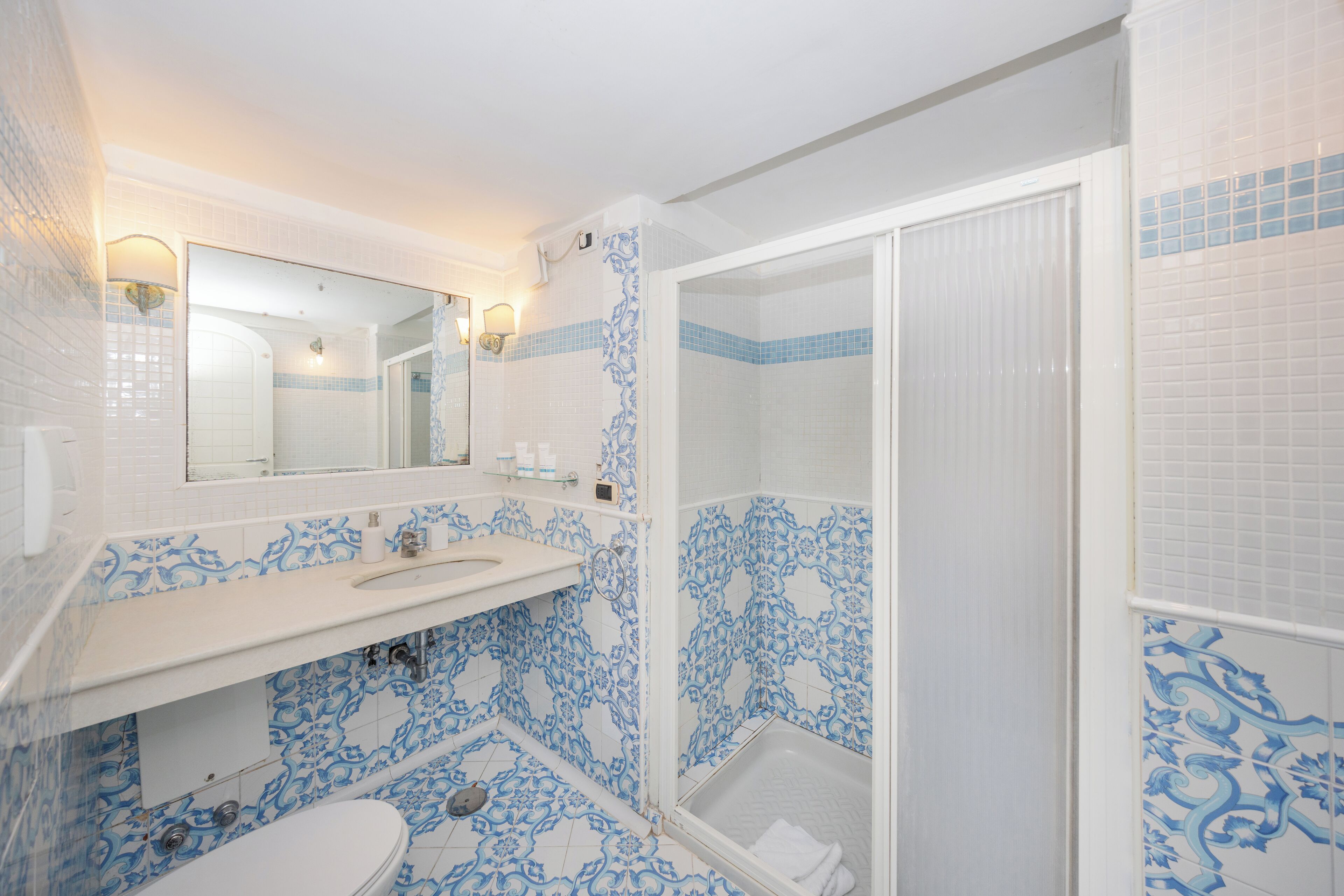 Een badkamer met een wit wastafel, toilet en douche.