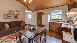Una cocina acogedora con armarios de madera, una mesa de comedor y un ventilador de techo.