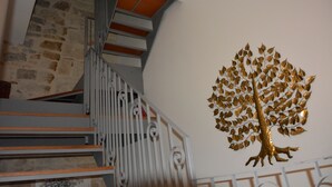 A staircase with a decorative golden tree on the wall. - AFFITTACAMERE DIMORA DEL CARMINE (Bari)