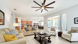 A spacious living room with a ceiling fan, a coffee table, and two sofas.