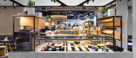Un café moderno con una variedad de alimentos y bebidas exhibidos en una vitrina.