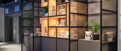 A modern interior with a sectional bookshelf, a round table, and a potted plant.