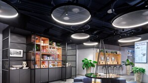 Un interior moderno con una zona de estar central, una estantería y una pizarra de menú.
