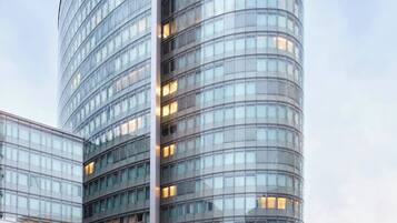 A modern glass building with a curved facade and multiple windows.