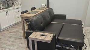 A modern living room with a sofa, a coffee table, and a dining table. - Private & cozy suite located in Fort Langley (Langley Township)