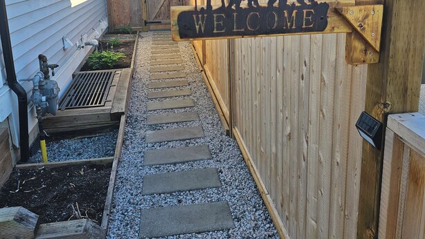 A wooden fence with a 'WELCOME' sign featuring a bear and trees. - Private & cozy suite located in Fort Langley (Langley Township)