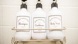 Three bottles of home collection cleaning products on a metal shelf. - Sunburst Inn The Beachside Suite - Room 5 (Indian Shores)