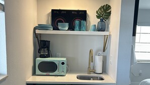 A compact kitchenette with a microwave, coffee maker, and a sink. - Sunburst Inn The Beachside Classic - Room 4 (Indian Shores)