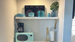 A compact kitchenette with a retro-style microwave, a coffee maker, a sink, and a small refrigerator. - Sunburst Inn The Beachside Classic - Room 4 (Indian Shores)