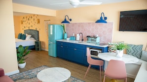 A compact living space with a bed, kitchenette, dining area, and a small seating area. - Sunburst Inn The Beachfront Suite - Room 11 (Indian Shores)