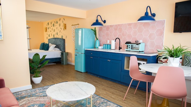 A compact living space with a bed, kitchenette, dining area, and a small seating area. - Sunburst Inn The Beachfront Suite - Room 11 (Indian Shores)