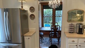 A kitchen with a stainless steel refrigerator, a chandelier, a dining table with chairs, and a rug. - Historic 2 bedroom home in downtown Stevensville. Pet friendly! RV parking (Stevensville)