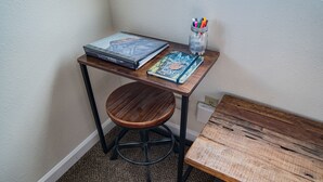 A corner workspace with a wooden desk, a stool, and a small table. - Mt Williamson Motel and Basecamp (Independence)