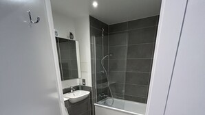 Un baño moderno con inodoro, lavamanos y zona de ducha.