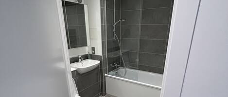 A modern bathroom with a toilet, sink, and shower area.