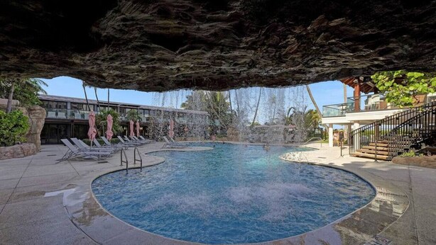 A pool area with a hot tub, lounge chairs, and a covered seating area. - Cozy Beachfront 2 BDR Miami Beach Condo 406 (Miami Beach)
