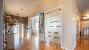 Una habitación amplia con suelo de madera, un separador de vidrio y un cuadro en la pared.