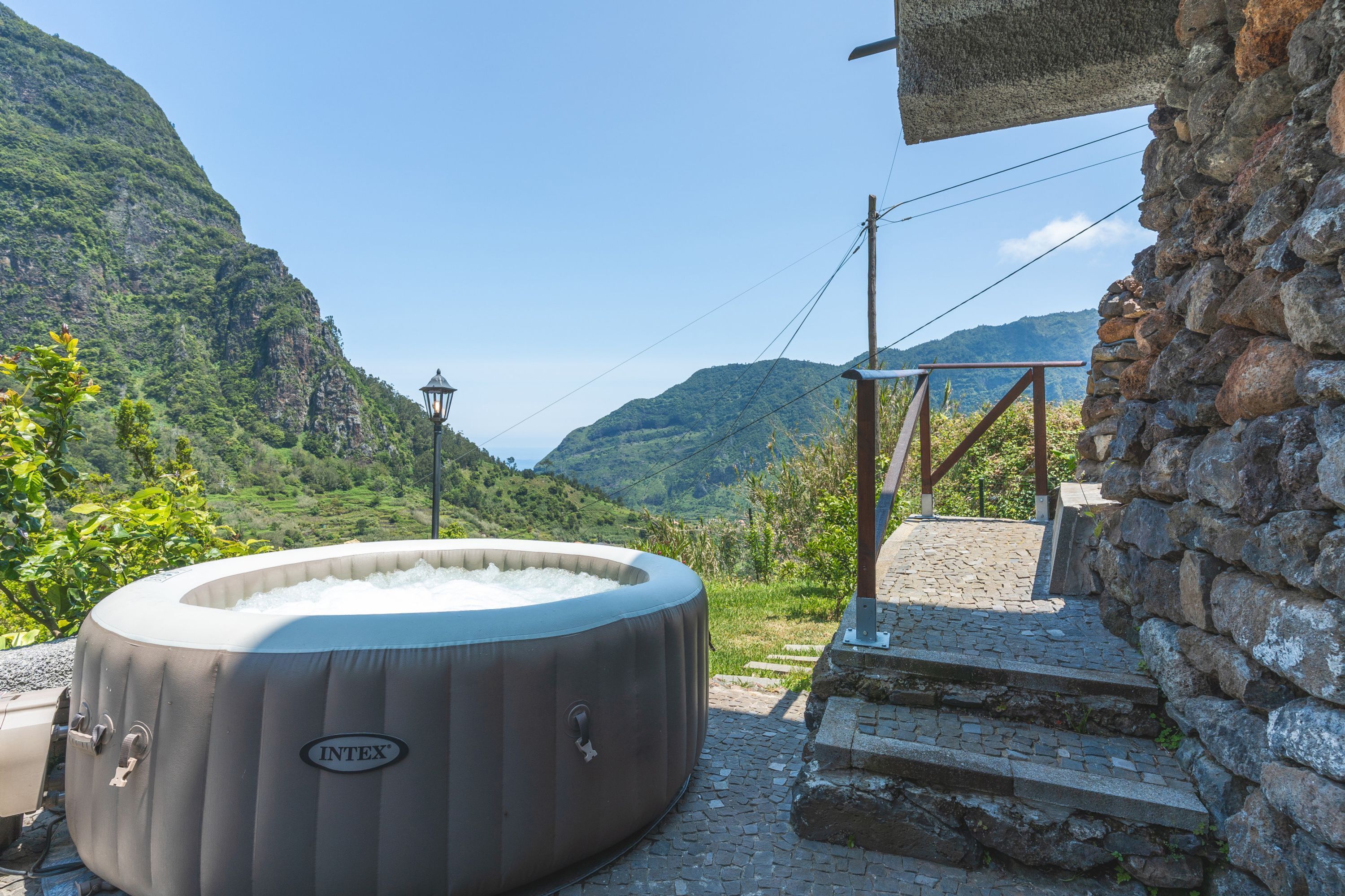 A hot tub labeled 'INTEX' outdoors with a mountainous backdrop.