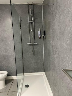 Chuveiro, toalhas de banho, sabonete, papel higiênico