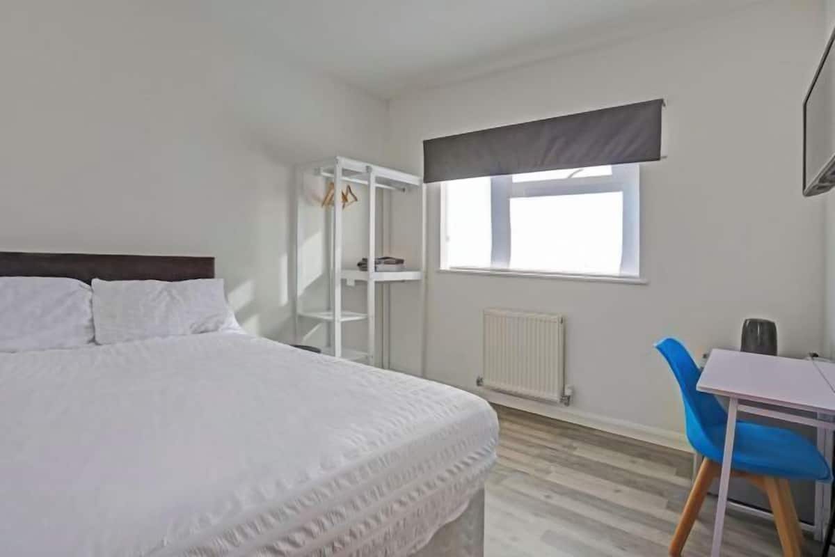 Desk, iron/ironing board, bed sheets