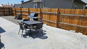 A patio with a grill, a table, and four chairs. - Modern Central Blackfoot Living (Blackfoot)
