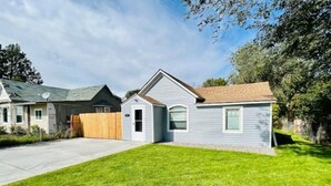 A residential house with a well-maintained lawn, a driveway, and a wooden fence. - Modern Central Blackfoot Living (Blackfoot)