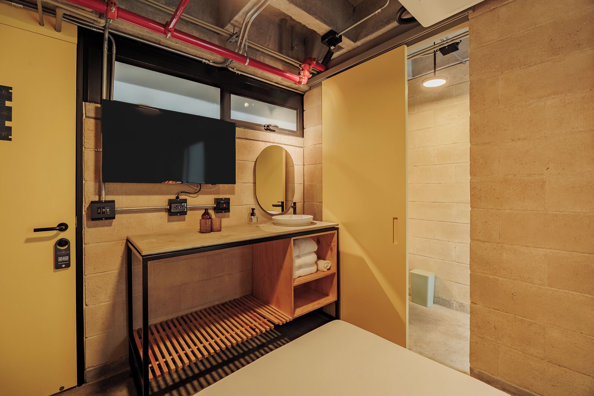 A compact bathroom with a sink, mirror, and towel rack.