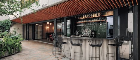 A bar area with a counter, stools, and a view of the street.