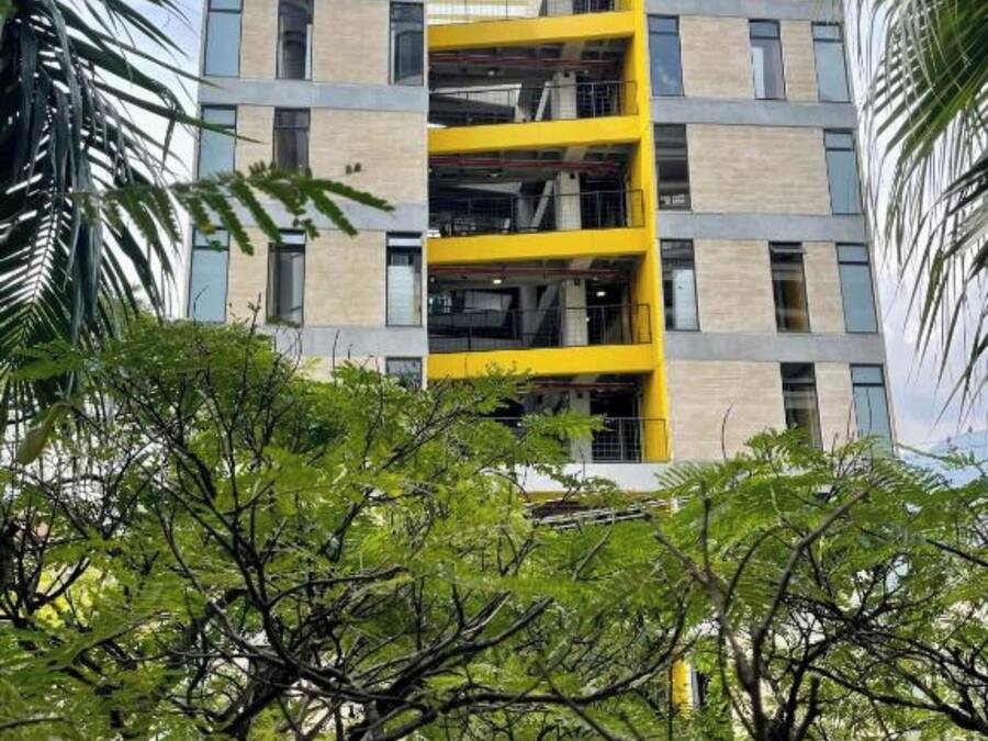 Un edificio de varios pisos con fachada amarilla y varios balcones.
