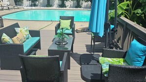 A deck with outdoor furniture, a pool, and a view of the surrounding greenery. - Hidden Oasis (Martinez)