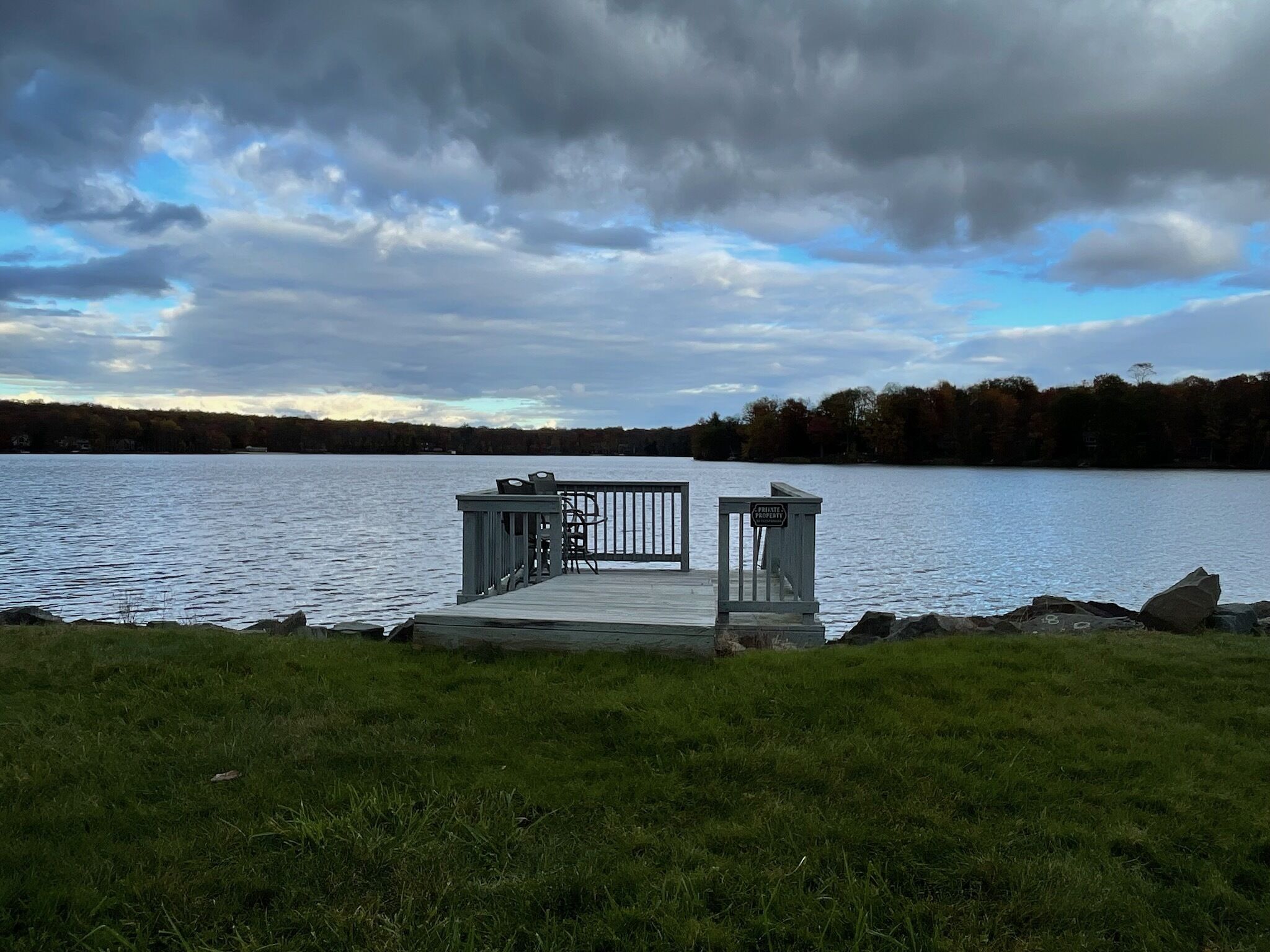 A dock with a small seating area and a sign indicating private property.