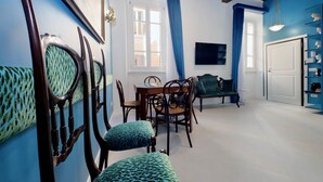A room with a dining table, chairs, a sofa, and a bookshelf. - 2 steps from the Spanish Steps (Roma)