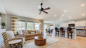A spacious living room with a sofa, armchairs, a coffee table, and a dining area with chairs and a table. - Private Patio + Lake View: Fruit Cove Home (Fruit Cove)