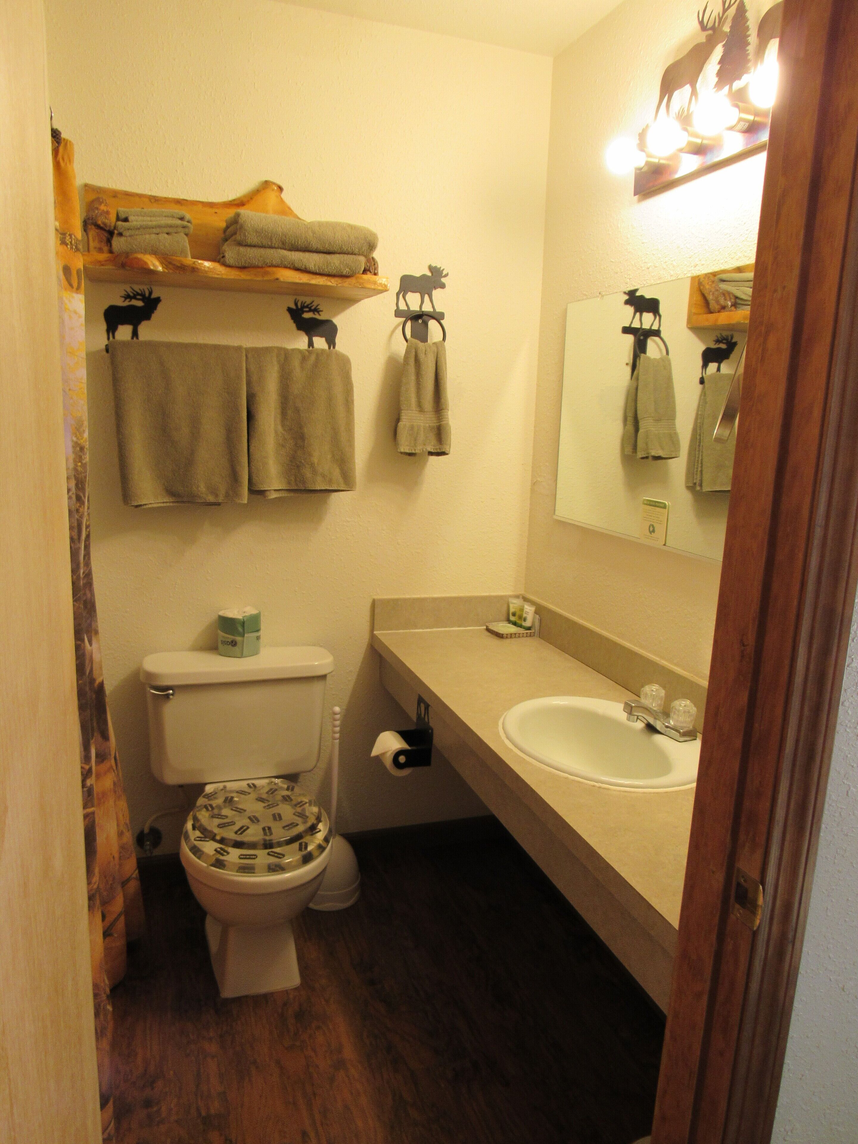 Een compacte badkamer met toilet, wastafel en handdoekhouder.