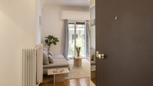 A modern living room with a sofa, coffee table, and a radiator. - Kerameikou25 small ·  Excellent value for money in (Athens)
