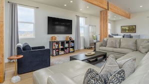 A modern living room with a sofa, coffee table, and bookshelf. - Newly renovated Barnhouse on 13 acres brings you a modern feel to your retreat.  (Grand Junction)